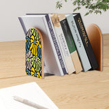 Yellow Abstract Floral retro bookend holding books on a wooden desk next to a pen
