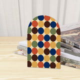 Close-up of the Multicolor Dots retro wooden bookend beside stacked magazines