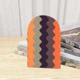 Close-up of the Peach Chevron retro wooden bookend beside stacked magazines