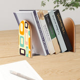 Orange Mod Shapes retro bookend holding books on a wooden desk next to a pen