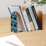 Teal Wave Rings retro bookend holding books on a wooden desk next to a pen