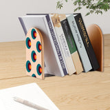 Target Dots retro bookend holding books on a wooden desk next to a pen