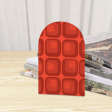 Close-up of the Red Squares retro wooden bookend beside stacked magazines