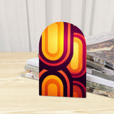 Close-up of the Purple Op-Art retro wooden bookend beside stacked magazines