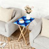Blue Peacock Eye retro TV tray set of 4, next to a grey sofa with flowers