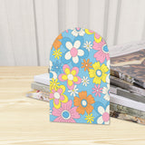 Close-up of the Pastel Daisy retro wooden bookend beside stacked magazines