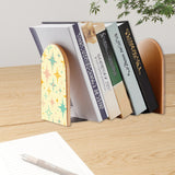 Atomic Stars retro bookend holding books on a wooden desk next to a pen
