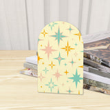 Close-up of the Atomic Stars retro wooden bookend beside stacked magazines
