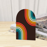 Close-up of the Rainbow Arcs retro wooden bookend beside stacked magazines
