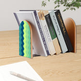 Green Zigzag retro bookend holding books on a wooden desk next to a pen