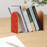 Red Squares retro bookend holding books on a wooden desk next to a pen