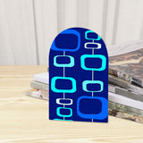 Close-up of the Blue Atomic Squares retro wooden bookend beside stacked magazines