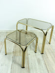 TWO 1970s NESTING TABLES with smoked glass top, golden chromed metal