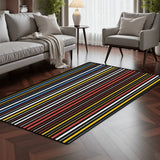 Dark striped area rug 3x5 ft with colorful thin stripes in a living room with a gray sofa and armchair on dark wood flooring