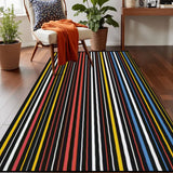 Top view of dark striped area rug 3x5 ft with colorful thin stripes on a wood floor beside an armchair with an orange throw