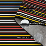 Folded corner of the dark striped rug showing soft surface, edge binding and anti-slip TPR backing