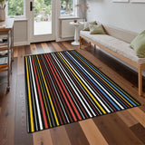Dark striped area rug 3x5 ft with colorful thin stripes on a wood floor in front of a sofa near a glass door