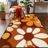 Top view of brown orange daisy pattern area rug 3x5 ft on a wood floor beside an armchair with an orange throw