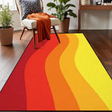Top view of orange red yellow wave pattern area rug 3x5 ft on a wood floor beside an armchair with an orange throw