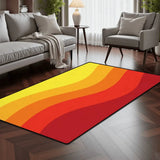 Orange red yellow wave pattern area rug 3x5 ft in a living room with a gray sofa and armchair on dark wood flooring
