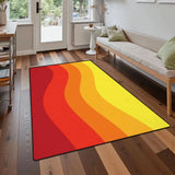 Orange red yellow wave pattern area rug 3x5 ft on a wood floor in front of a sofa near a glass door