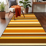 Top view of gold and brown striped area rug 3x5 ft on a wood floor beside an armchair with an orange throw