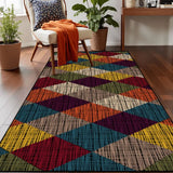 Top view of burgundy navy yellow diamond pattern area rug 3x5 ft on a wood floor beside an armchair with an orange throw
