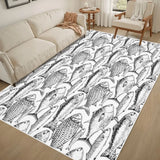 Cream sofa and armchair beside a 4x6 ft black and white fish area rug