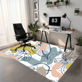 White leaf art area rug 3x5 ft in olive, pink, blue-gray under a black office chair at a home office desk
