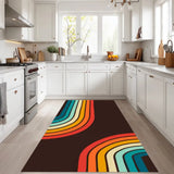 Rainbow striped 3x5 ft area rug placed in a white kitchen in front of the counters