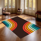 Dark brown 3x5 ft area rug with rainbow stripe arcs on a parquet floor by tall windows