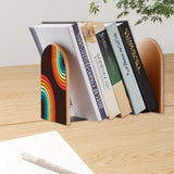 Rainbow Arcs retro bookend holding books on a wooden desk next to a pen