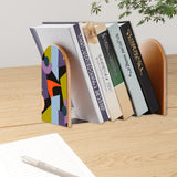 Abstract Shapes retro bookend holding books on a wooden desk next to a pen