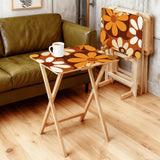 Brown Orange Daisies retro TV tray set of 4, in a living room beside an olive sofa
