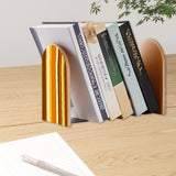 Brown Stripe retro bookend holding books on a wooden desk next to a pen