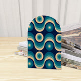 Close-up of the Teal Wave Rings retro wooden bookend beside stacked magazines