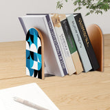 Blue Geometric retro bookend holding books on a wooden desk next to a pen