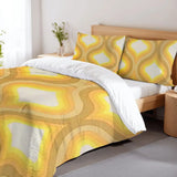 Golden yellow ogee duvet cover set on a bed with a wooden headboard and a flower vase