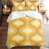 Full duvet cover set with golden yellow ogee shapes on a bed with white sheets and wooden nightstands