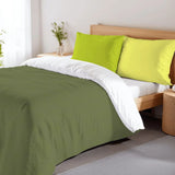 Olive green duvet cover set with lime pillowcases on a bed with a wooden headboard