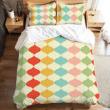 Full duvet cover set with red, teal, peach and green harlequin diamonds on a bed with white sheets
