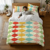 Person lying on a bed under the harlequin duvet cover, seen from above