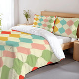 Harlequin duvet cover set on a bed with a wooden headboard and a flower vase