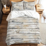 Full duvet cover set with a rustic gray wood plank print on a bed with white sheets