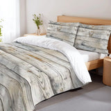 Rustic gray wood plank duvet cover set on a bed with a wooden headboard and a flower vase
