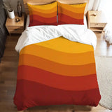 Full duvet cover set with orange, yellow and red wave stripes on a bed with white sheets and a nightstand