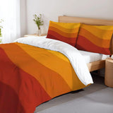 Orange and red wave stripes duvet cover set on a bed with a wooden headboard and a flower vase