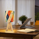 Same atomic harlequin design on a tripod table lamp shade on a wooden desk