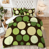 King comforter set with green, cream and brown polka dots on a bed with a tufted white headboard