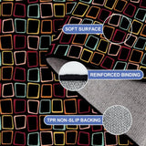 Close-up of the rug, black with colorful outlined squares, with a folded corner showing binding and backing